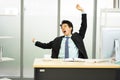 Sleepy asian man stretching yawning at workplace, tired man feel lazy and unmotivated distracted from computer job, sleep