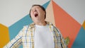 Sleepy Asian mature man yawning feeling fatigue and sleepiness at home studio