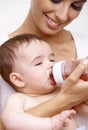 Sleepy baby drinking tea from feeding bottle