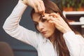 Sleepy businesswoman in office. Young tired brunette stickes tape on her eyes so she don`t sleep. Close up portrait Royalty Free Stock Photo