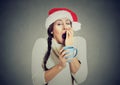 Sleepy christmas woman yawning holding cup of hot beverage