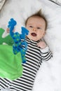 Sleepy cute baby lying in crib or cot bed, looking at crib mobile toys Royalty Free Stock Photo