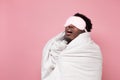 Sleepy dark haired man in medical mask holding white blanket