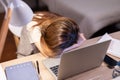 Exhausted asian woman sleep with her open laptop at home suffer from overtime working at night Royalty Free Stock Photo