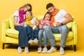 Family having flu with closed eyes while sitting on sofa on yellow Royalty Free Stock Photo