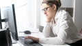 Sleepy female office worker sitting at big window