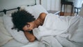 Sleepy girl laying bed morning. Curly hairstyle lazy woman waking up cozy room Royalty Free Stock Photo