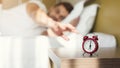 Sleepy guy waking up early after alarm clock signal Royalty Free Stock Photo