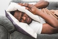 Sleepy guy waking up early after hearing alarm clock signal and does not want to get up. Royalty Free Stock Photo