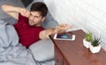 Sleepy guy waking up with mobile alarm clock Royalty Free Stock Photo