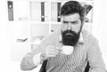 Sleepy half-awake hipster drink cup of coffee in workplace, caffeine