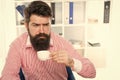 Sleepy half-awake hipster drink cup of coffee in workplace, caffeine