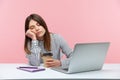 Sleepy inefficient woman office worker napping leaning head on hand and holding coffee cup sitting at workplace with laptop,