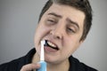 Sleepy man brushes his teeth with an electric brush. Oral hygiene concept. Tired man caring for teeth Royalty Free Stock Photo
