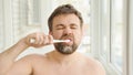 Sleepy man cleans teeth electric toothbrush Royalty Free Stock Photo
