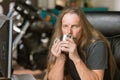 Sleepy Man at his Desk with Coffee and Motorcycle in the Background Royalty Free Stock Photo