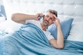 sleepy mature man in bed speaking on phone. headache Royalty Free Stock Photo