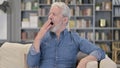 Portrait of Sleepy Senior Man Yawning on Sofa Royalty Free Stock Photo