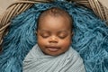 Sleepy swaddled African-American newborn baby boy