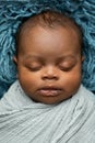 Sleepy swaddled African-American newborn baby boy
