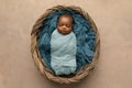 Sleepy swaddled African-American newborn baby boy