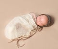 Sleepy swaddled newborn baby in knitted hat