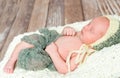 Sleepy swaddled newborn baby in knitted hat