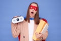 Sleepy tired brown haired woman wearing superhero costume holding documents in folders posing isolated over blue background