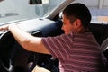 Sleepy tired caucasian young man sitting in car. 20s guy looking from open window. Silver grey gray car. Attractive