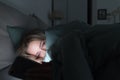 Sleepy tired woman lying in bed under the blanket using smartphone at late night, can not sleep. Insomnia, nomophobia, sleep Royalty Free Stock Photo