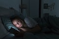 Sleepy tired woman lying in bed under the blanket using smartphone at night, can not sleep.Insomnia Royalty Free Stock Photo