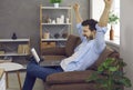 Sleepy tired young man stretching arms and yawning while working on laptop at home Royalty Free Stock Photo