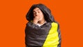 Sleepy tourist wrapped in sleeping bag, orange background Royalty Free Stock Photo