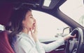 Sleepy woman driving her car after long hour trip isolated street background.