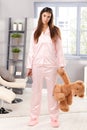 Sleepy woman in pyjama with teddy bear