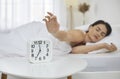 Sleepy woman snooze clock awaken in bed Royalty Free Stock Photo