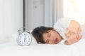 Sleepy woman trying turn off alarm clock in the morning Royalty Free Stock Photo