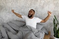 Sleepy young African American man yawning stretching after wake up Royalty Free Stock Photo