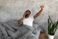 Sleepy young black guy yawning stretching after wake up Royalty Free Stock Photo