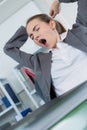 Sleepy young business woman sitting at office desk Royalty Free Stock Photo