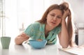 Sleepy young woman eating breakfast at home in morning Royalty Free Stock Photo