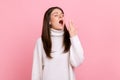 Sleepy young woman standing yawning with closed eyes and covering mouth, feeling exhausted need rest