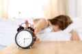 Sleepy young woman trying kill alarm clock Royalty Free Stock Photo