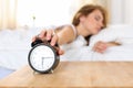 Sleepy young woman trying kill alarm clock Royalty Free Stock Photo