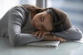 Tired woman employee sleeping on desk putting head on hands Royalty Free Stock Photo