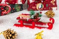 Sleigh of santa claus, boxes with gifts, christmas tree cone and golden bell on a background of snow Royalty Free Stock Photo
