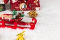 Sleigh of santa claus, boxes with gifts, christmas tree cone and golden bell on a background of snow Royalty Free Stock Photo