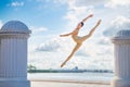 Slender ballerina in pointe shoes and bridal costume is jumping against the background of sea Royalty Free Stock Photo