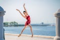 Slender ballerina in pointe shoes and bridal costume is jumping against the background of sea Royalty Free Stock Photo