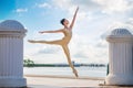 Slender ballerina in pointe shoes and bridal costume is jumping against the background of sea Royalty Free Stock Photo